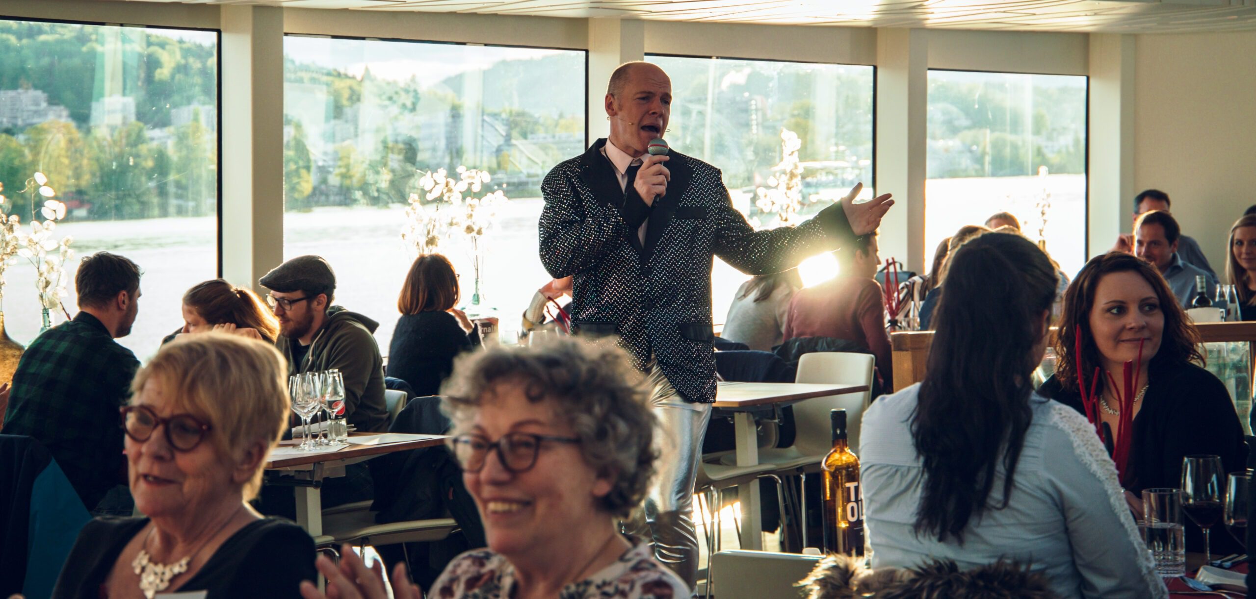 Mann in Anzug singt in einem vollen Restaurant