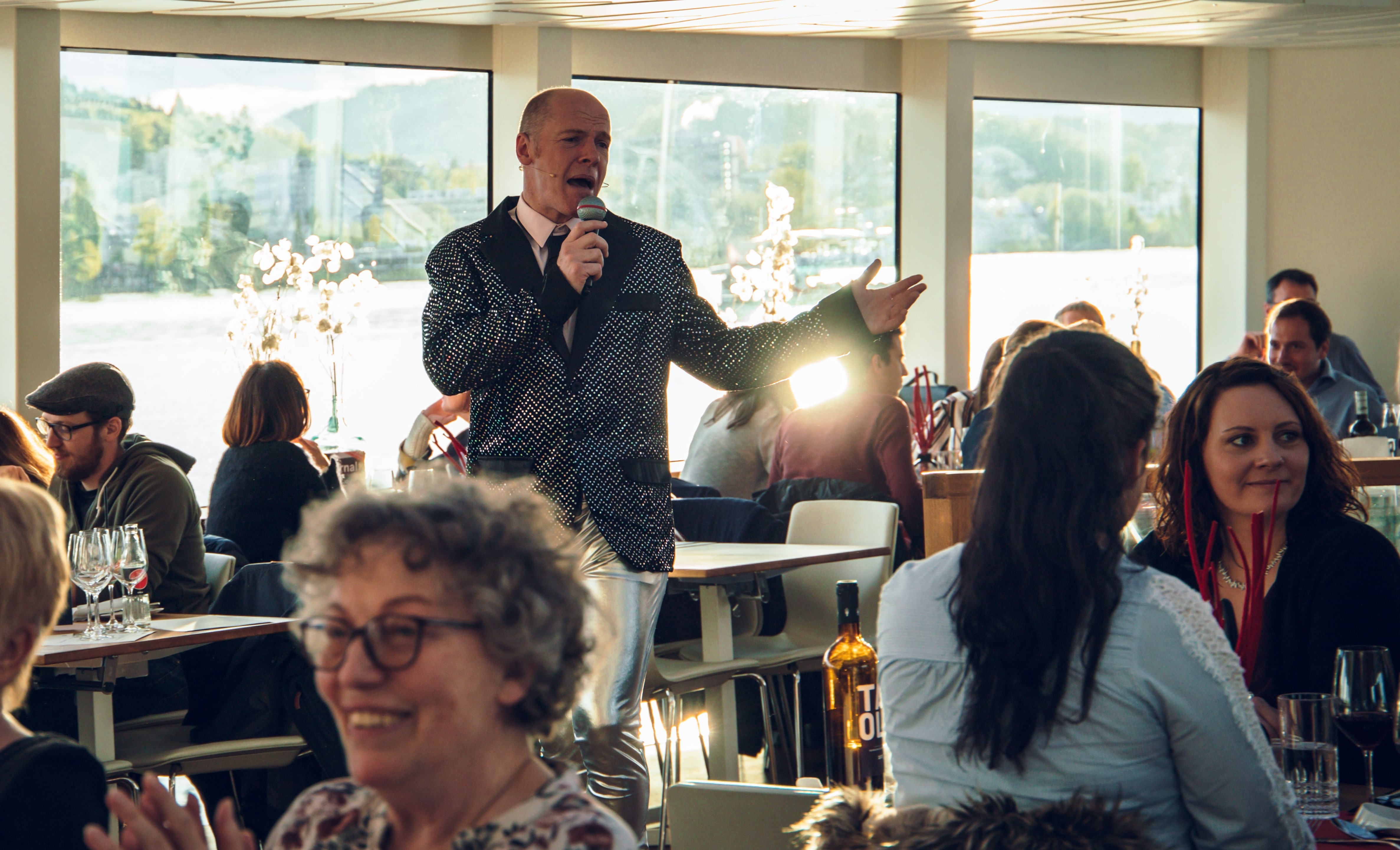 Mann in Anzug singt in einem vollen Restaurant